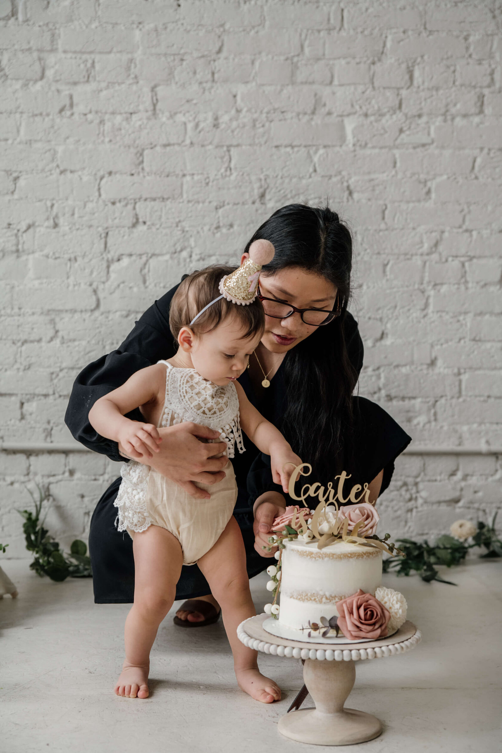 Mom showing baby girl her cake.