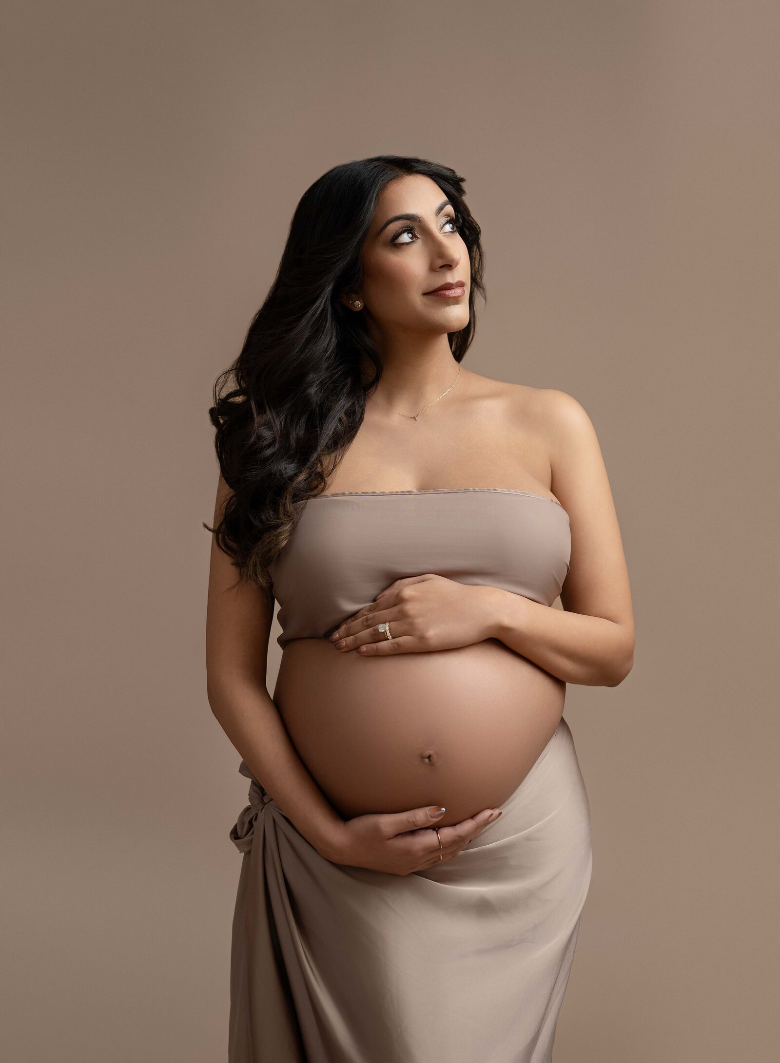 Mom wearing tan tube top and draped skirt, showing off baby bump. Photo taken at Atlanta Maternity photo studio in Woodstock, GA.