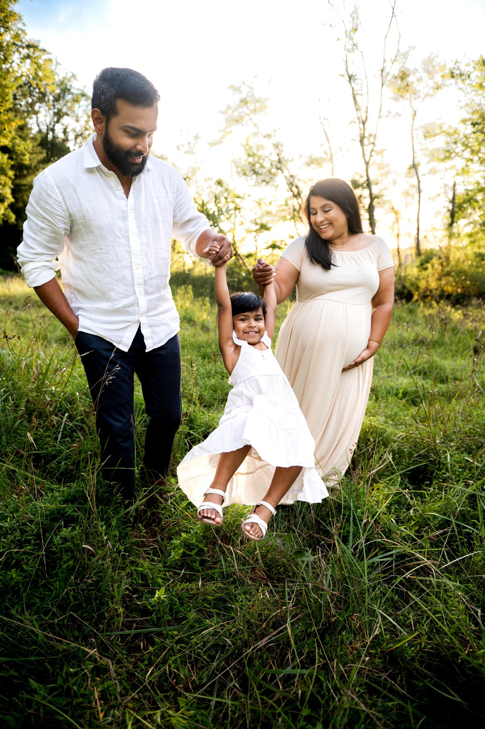 family in field for a maternity session at Loch Raven Reservoir