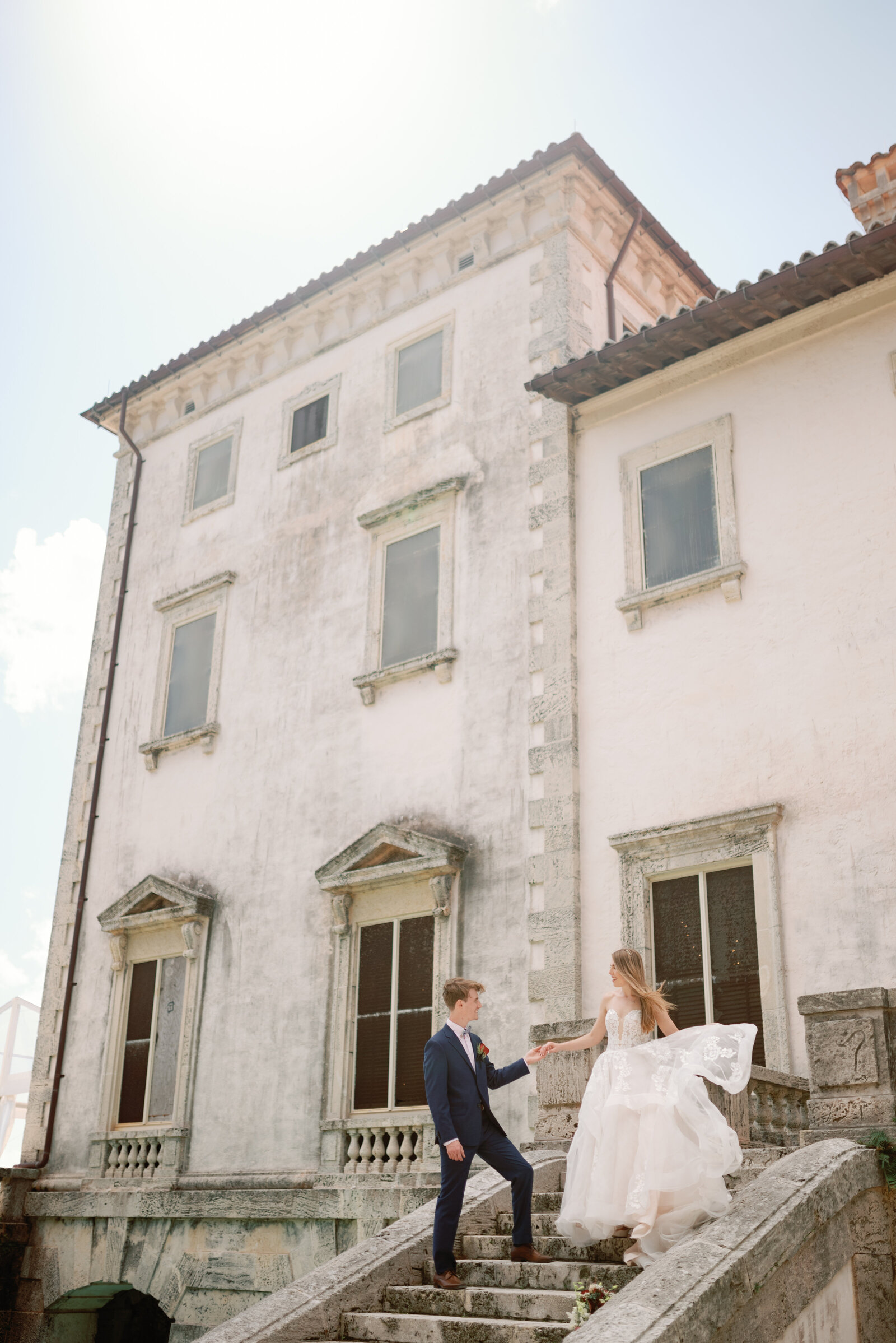 Groom leading bride down the steps at the historic Vizcaya Mansion