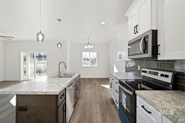 modern kitchen with marble counter tops white cabinets walls painted white and wood panel floors