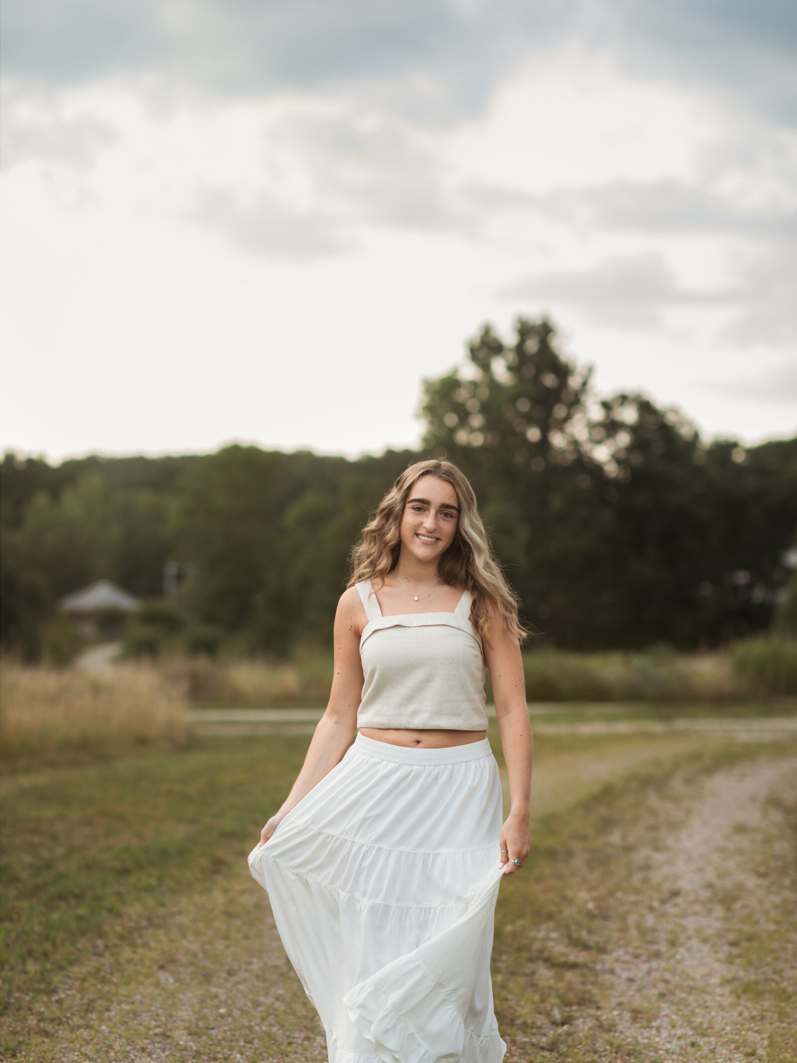high school senior girl in white dress at park for senior portraits 