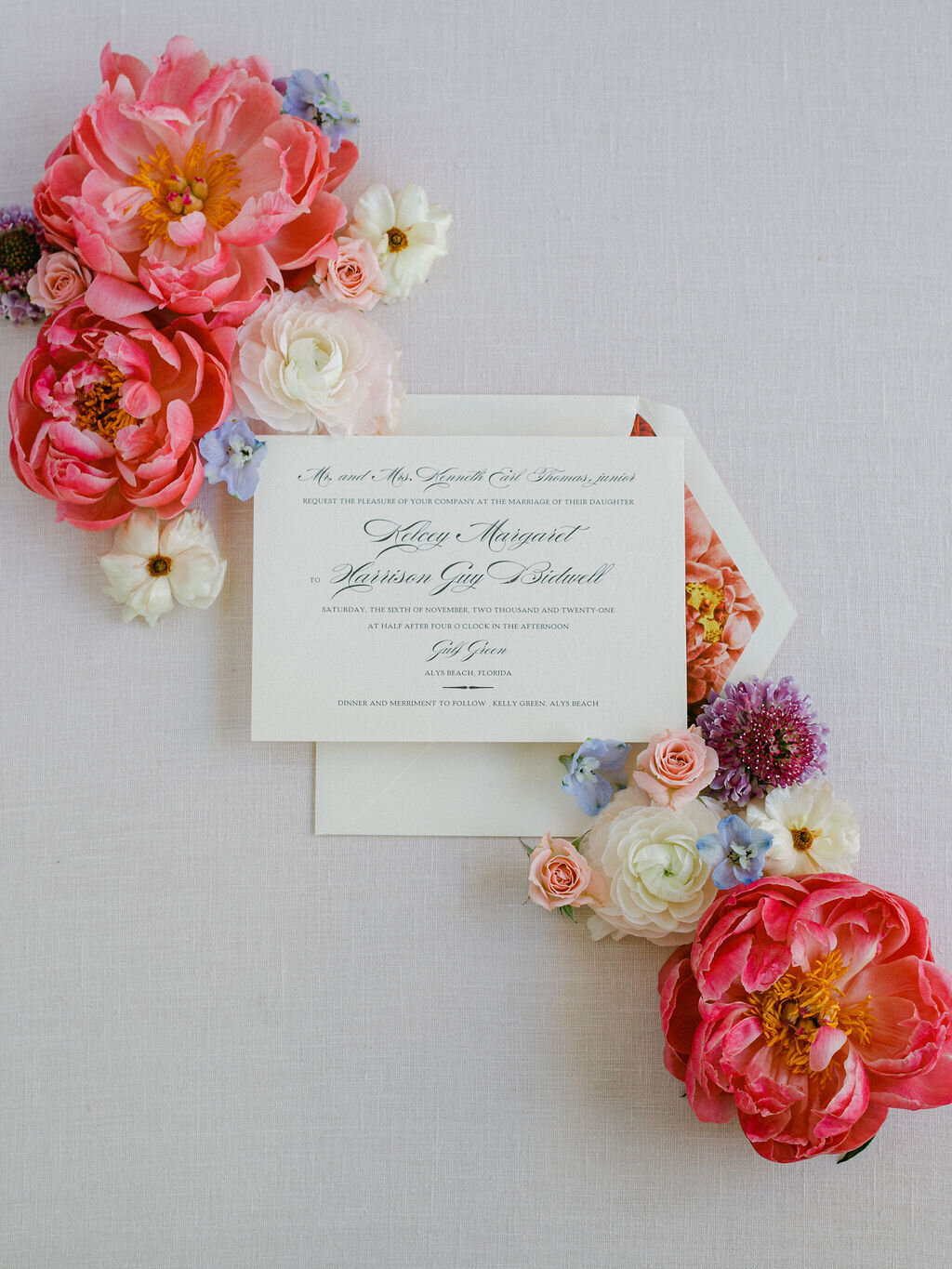 Flatlay of wedding invitations with colorful  florals