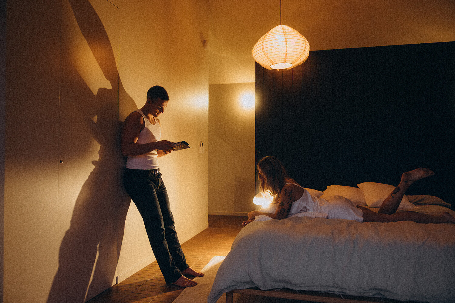 Moody warm lighting shot of a man reading a book to is fiance in a airbnb in the Noosa Hinterland. Captured by a Sunshine Coast Photographer