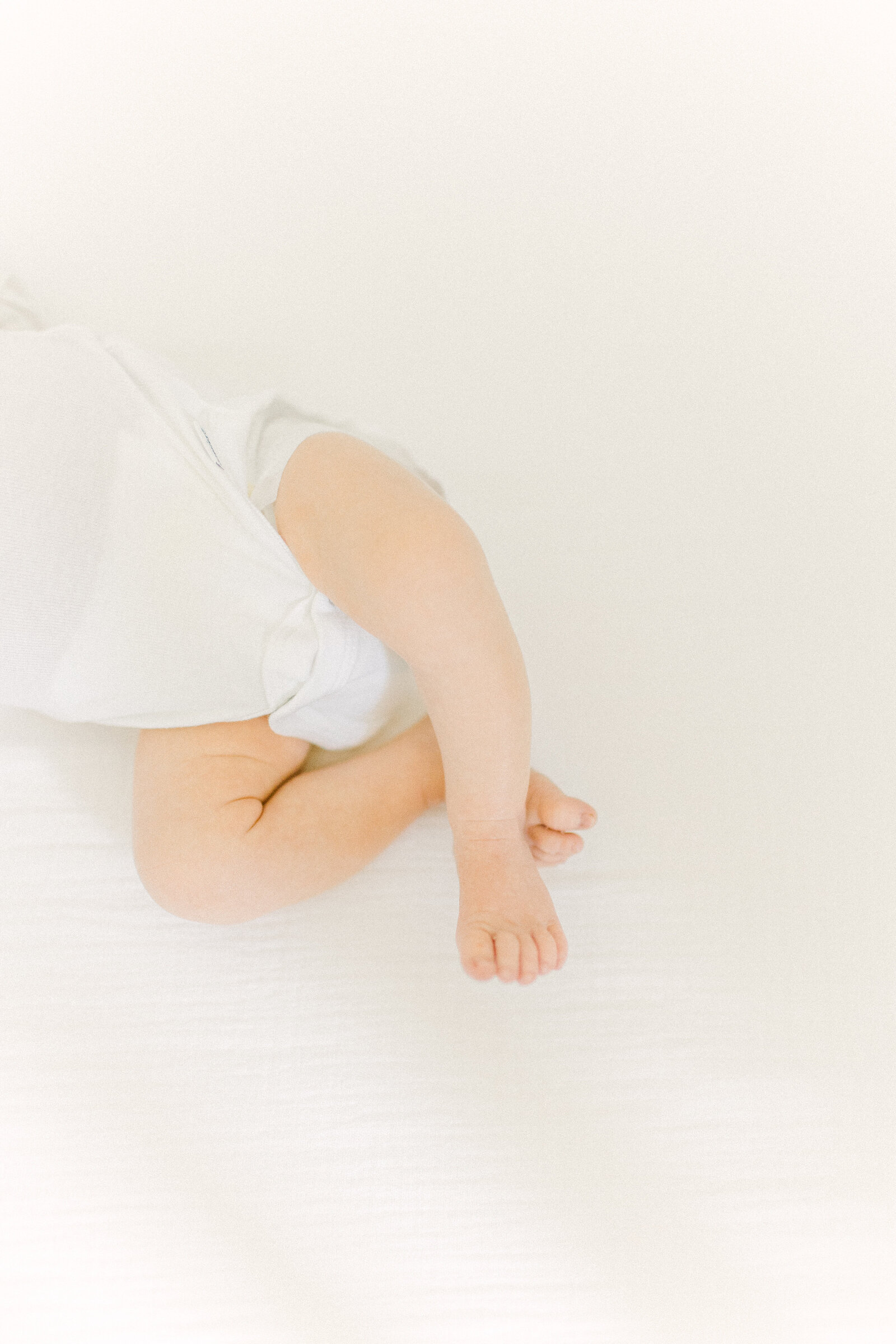 A close up image of a newborn baby's little legs and feet