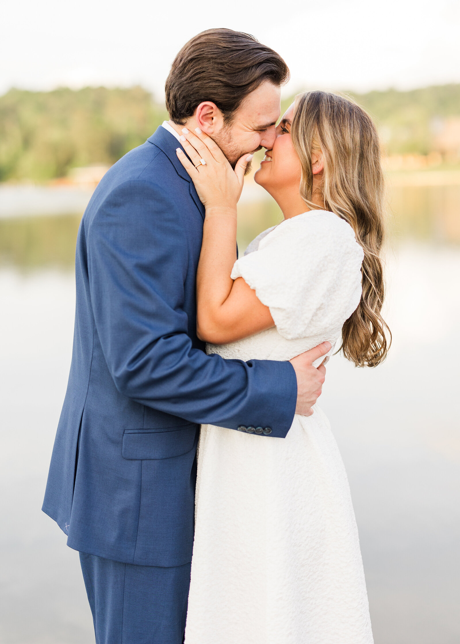 Close-up of Julianna and Josh sharing a heartfelt moment on a lakeside dock, photographed by Abby Bell Photography.