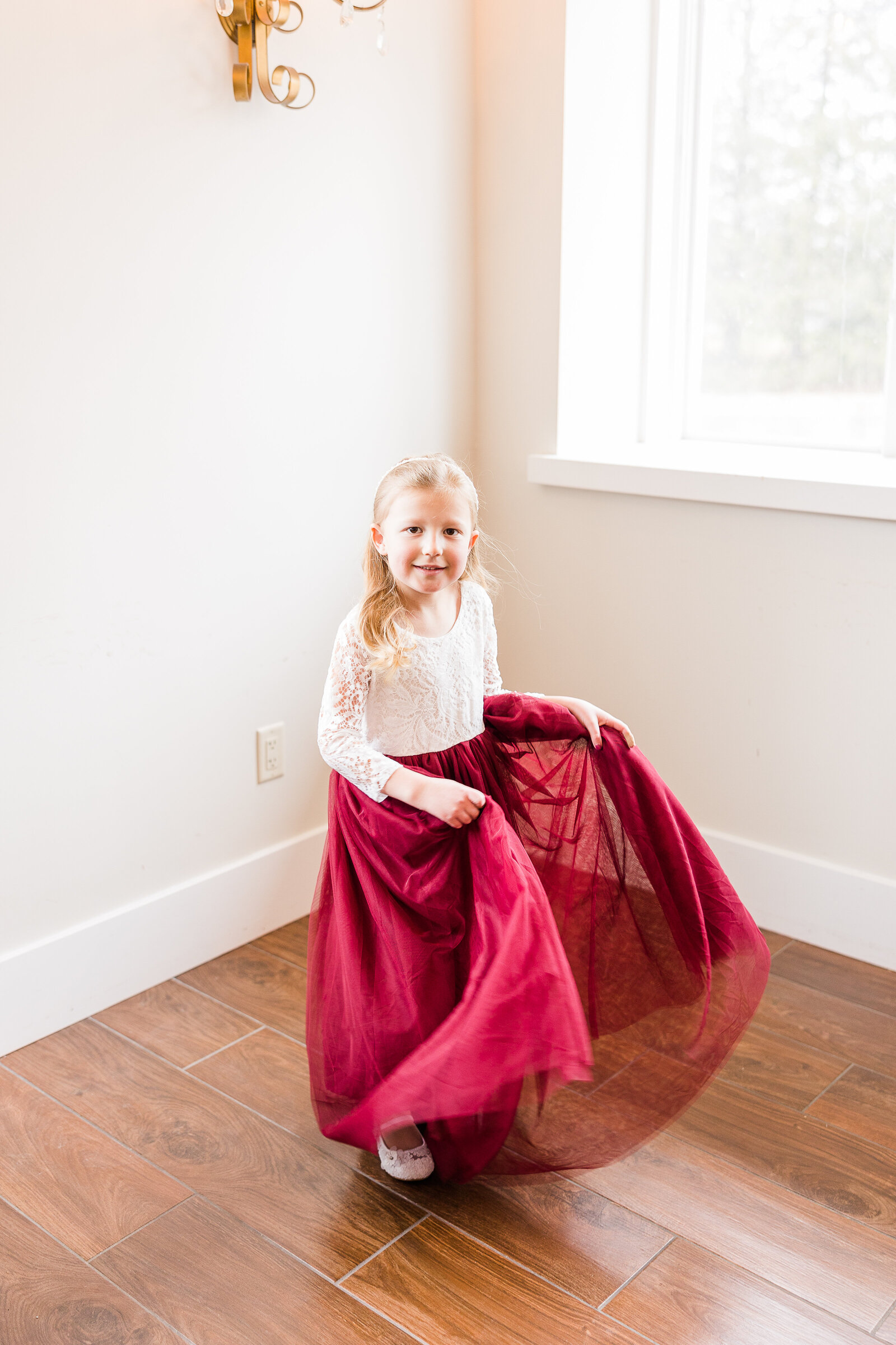 Another sweet moment of flower girl posing in her white and burgundy dress at a Perona Farms wedding
