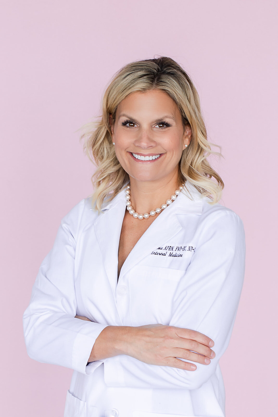 Female doctor headshot with pink background