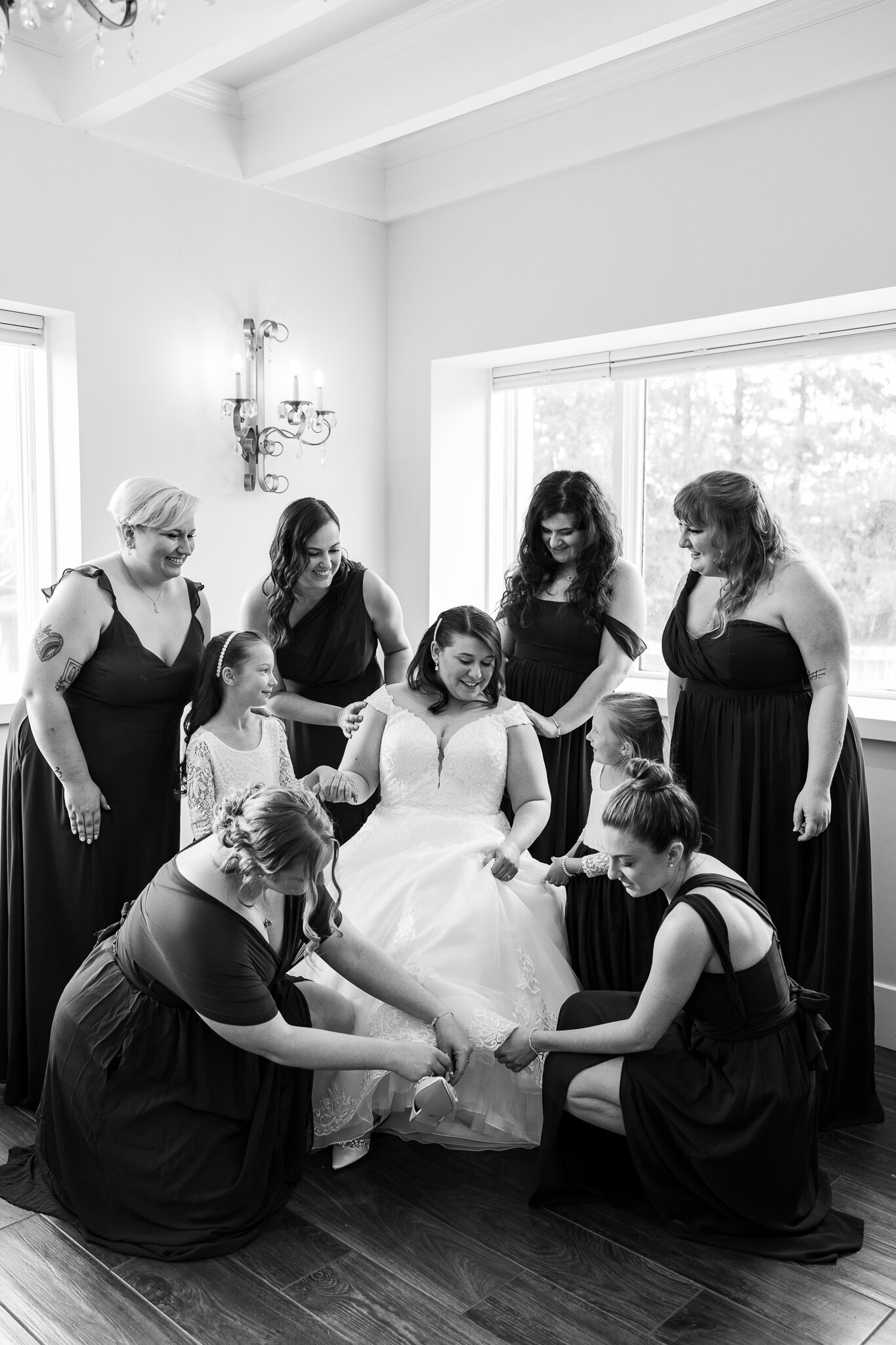 Black and white image of bridesmaids gathered around the bride during wedding morning at Perona Farms