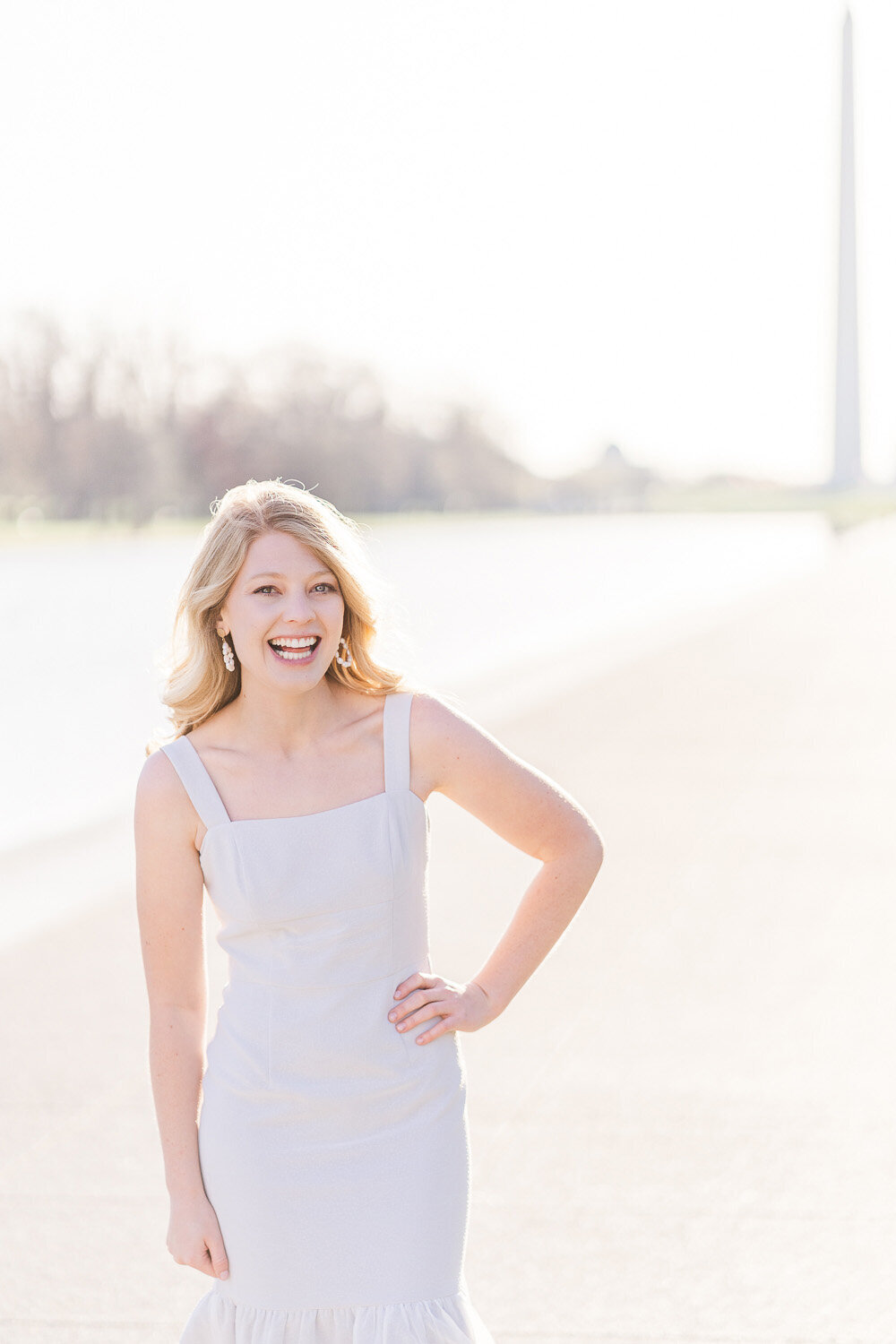 college girl laughing next to the reflecting pool during senior session