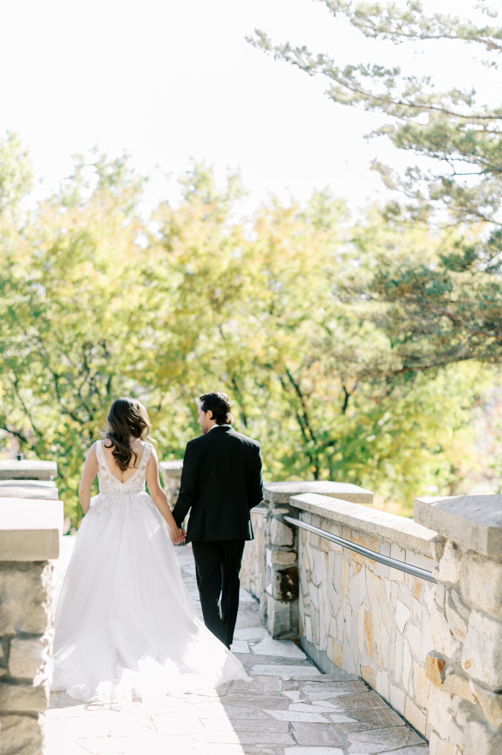 Boise wedding photography at Stone Crossing of bride and groom walking across the bridge