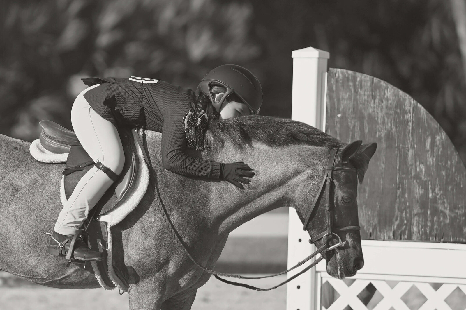 delray beach horse show photography of a girl patting and kissing her horse in the arena in black and white