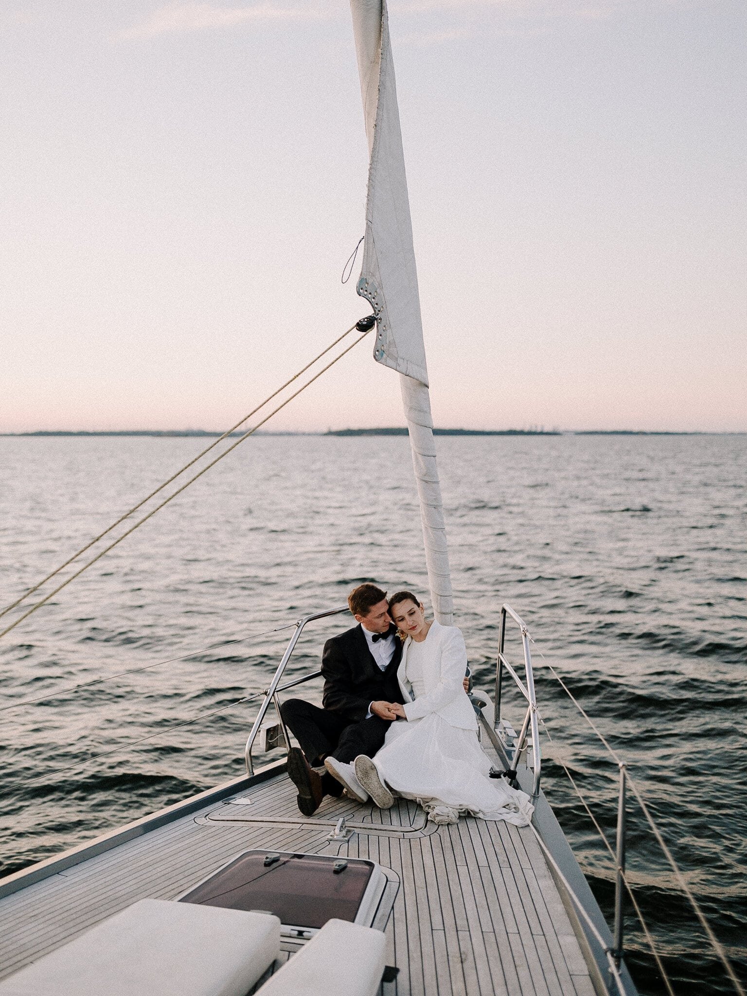 Couple sitting in sailboat after the sunset