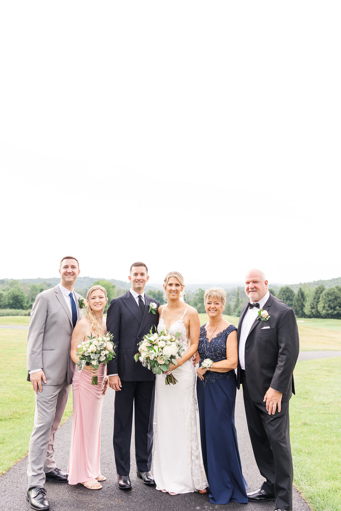 Bride posing with her family at SkyView Golf Club before the wedding ceremony
