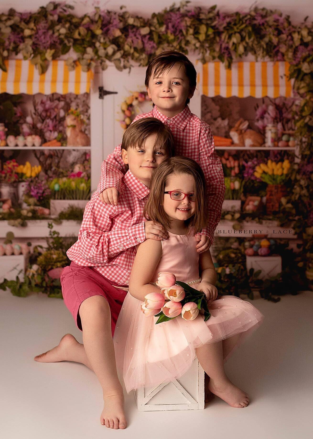 3 children having easter photos done in Oswego, ny wearing pink