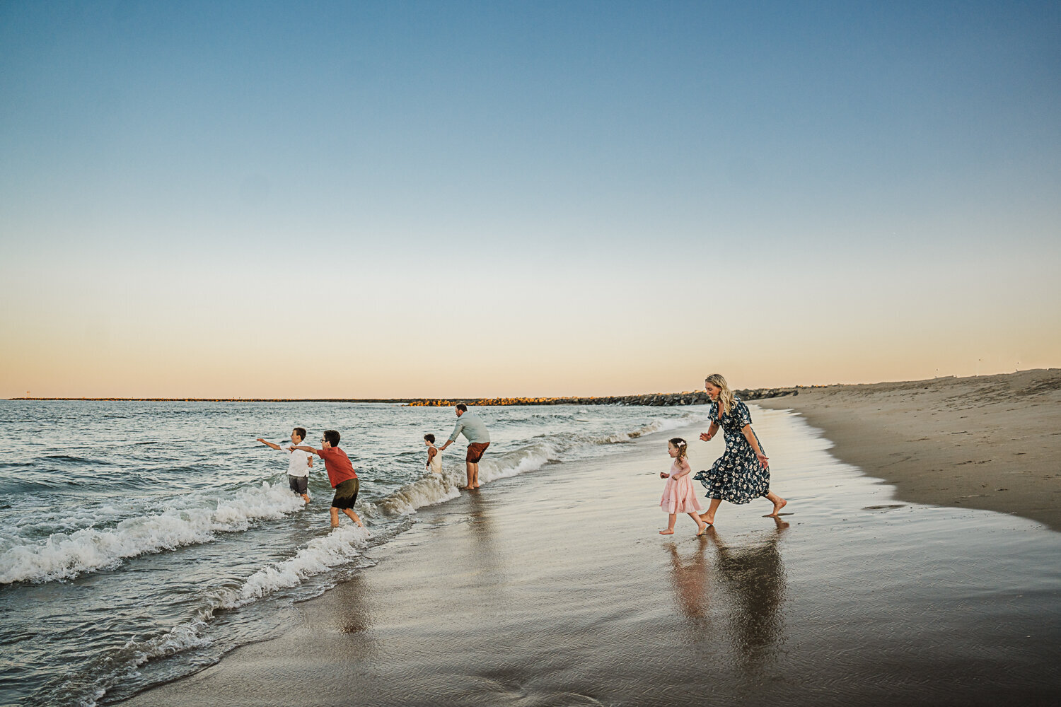 parents chase four kids into waves on boston beach