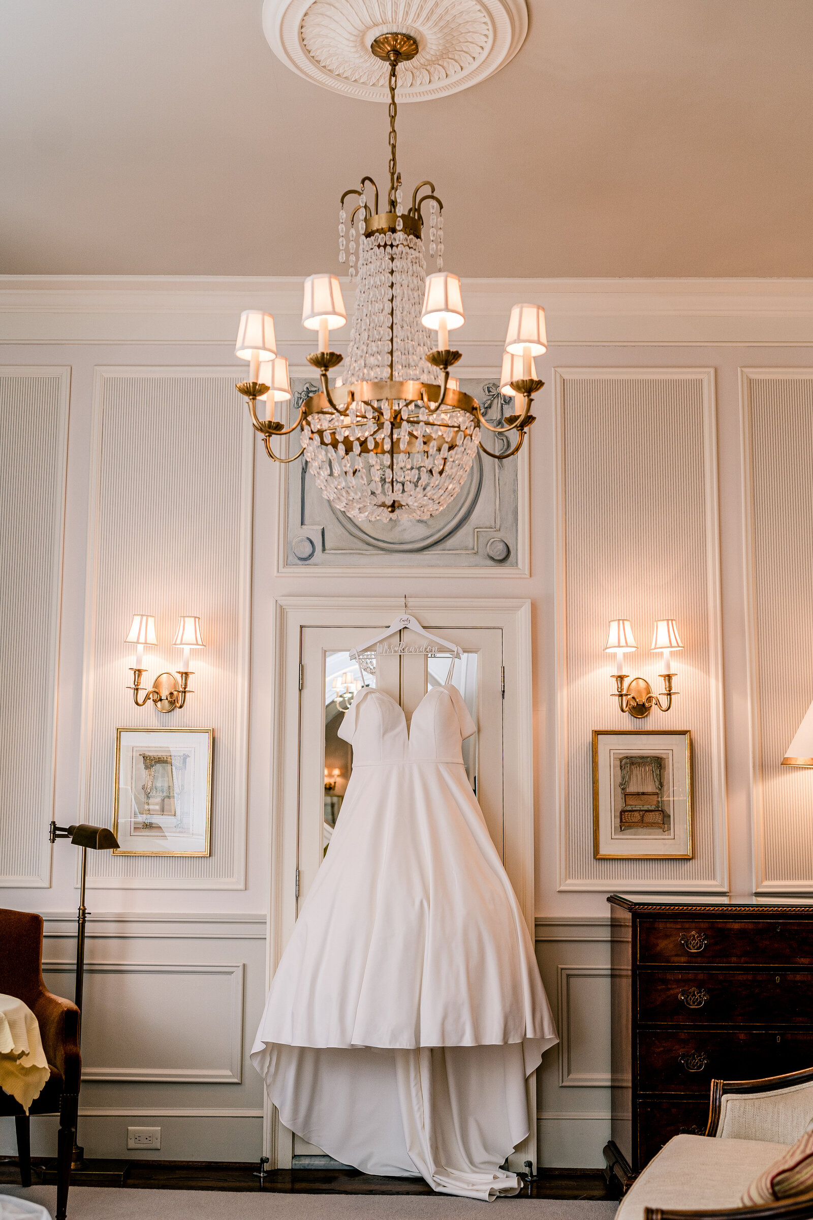 A wedding dress hanging from the doorway inside a beautiful hotel room for a wedding at The Inn at Little Washington in Virginia