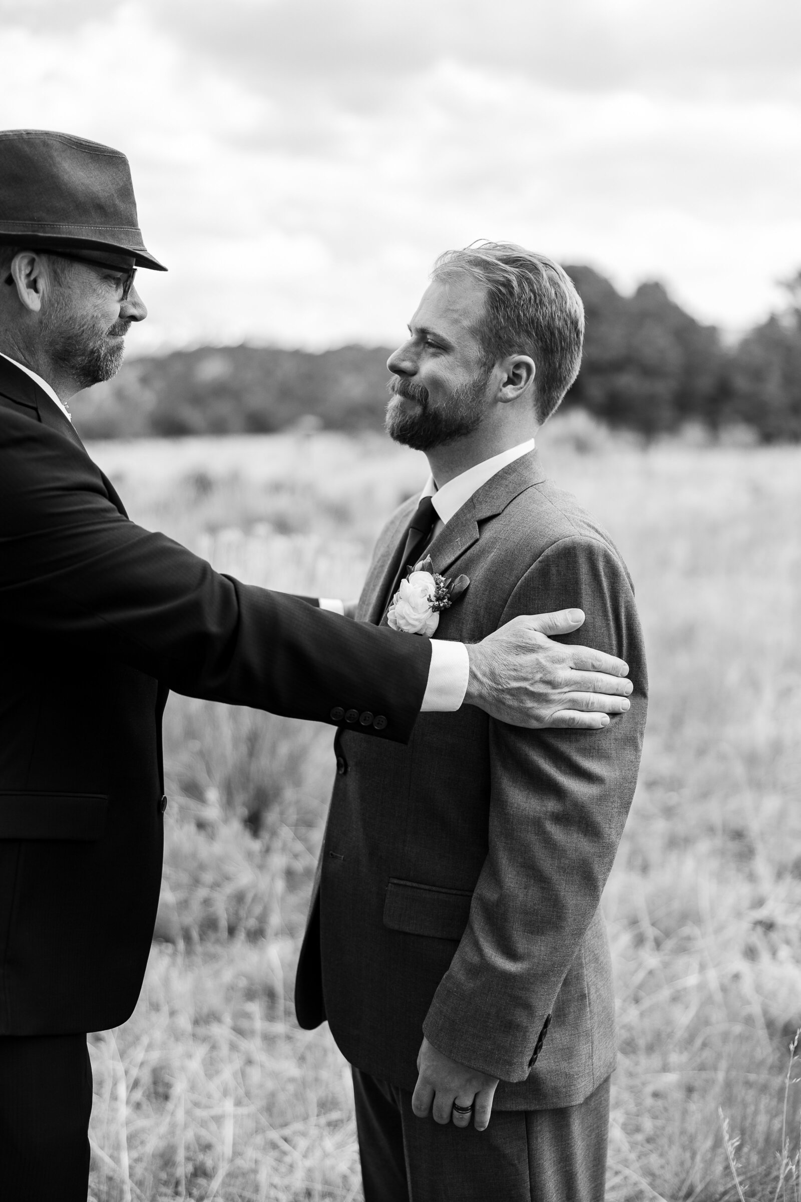 A heartfelt moment as the father of the groom congratulates his son after the ceremony at a Ridgway State Park wedding