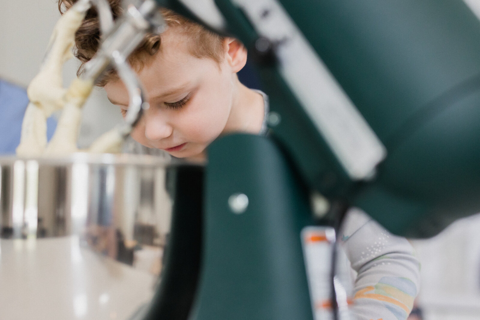 A little boy is busy baking in the background of a Kitchenaid Mixer