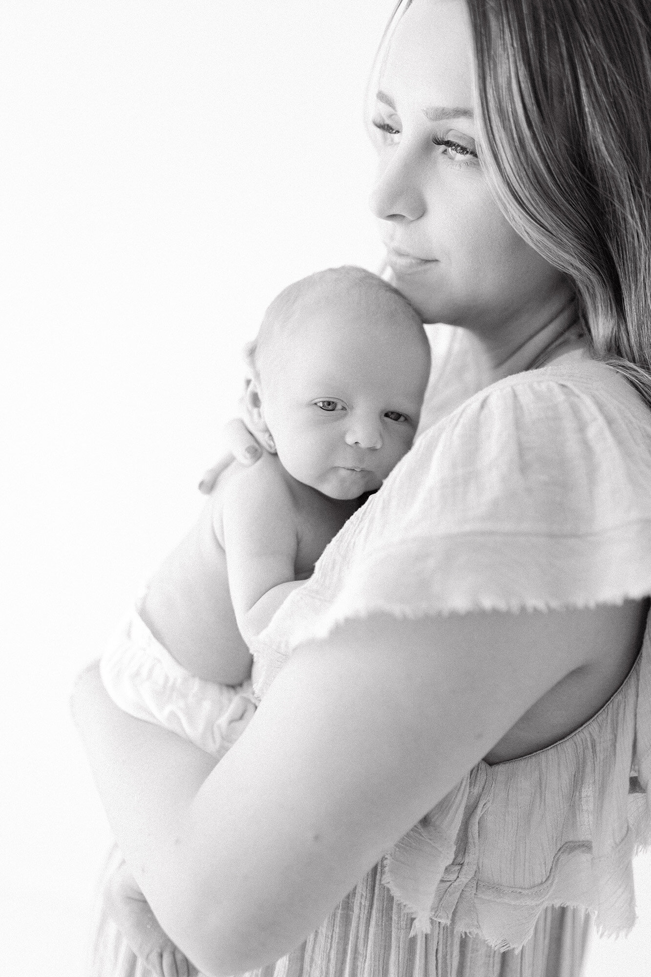 Tender moment of mother and newborn during lifestyle photo session in Grand Forks