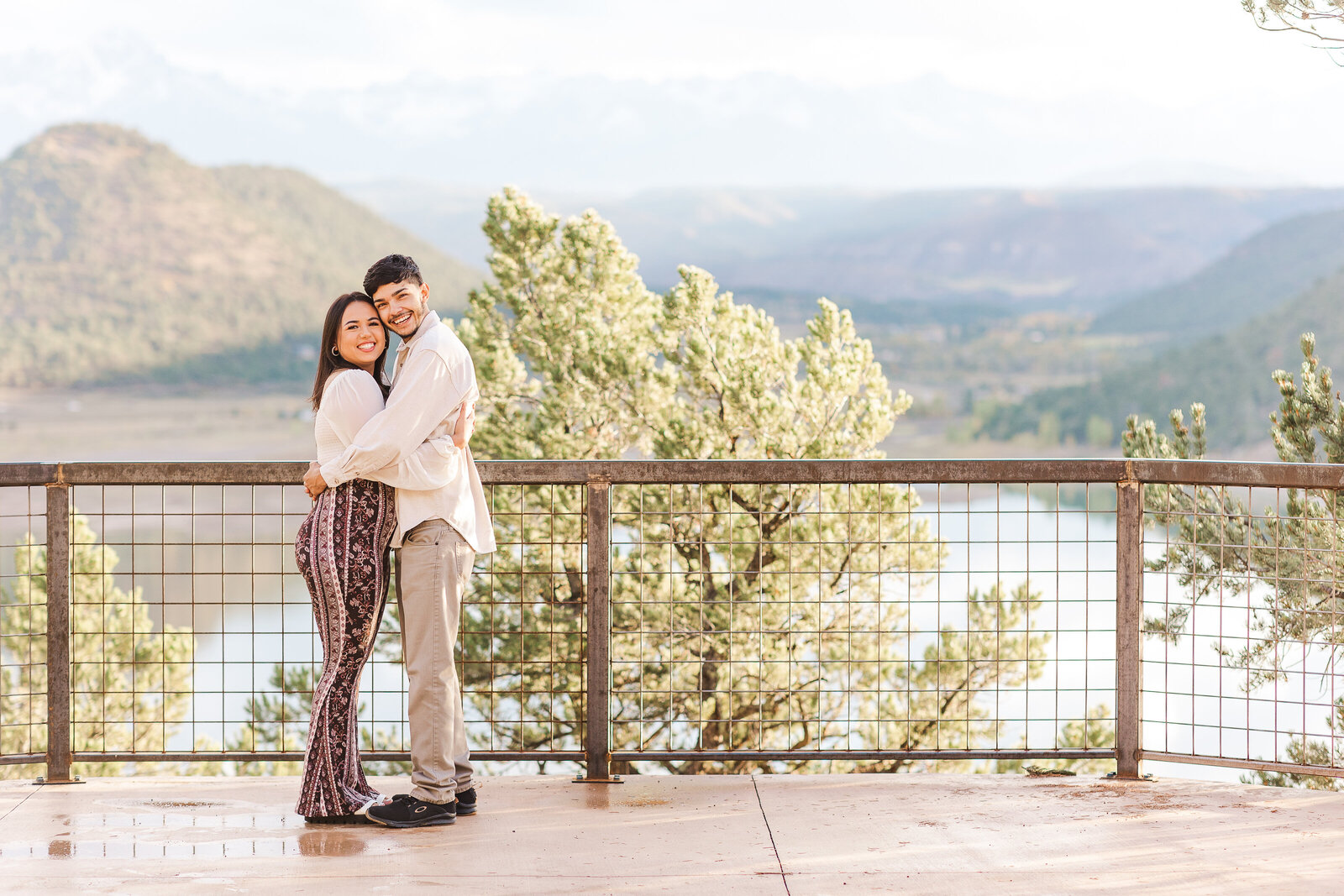 sweet boyfriend and girlfriend hold each other on deck overlooking ridgway lake