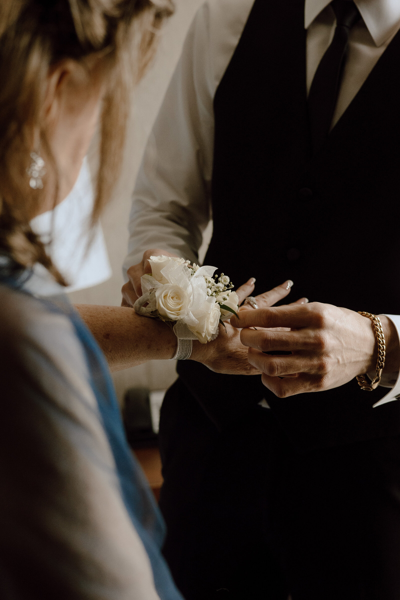Groom gifting a white wedding corsage to his mother before the wedding | Emma LeeAnn Photography