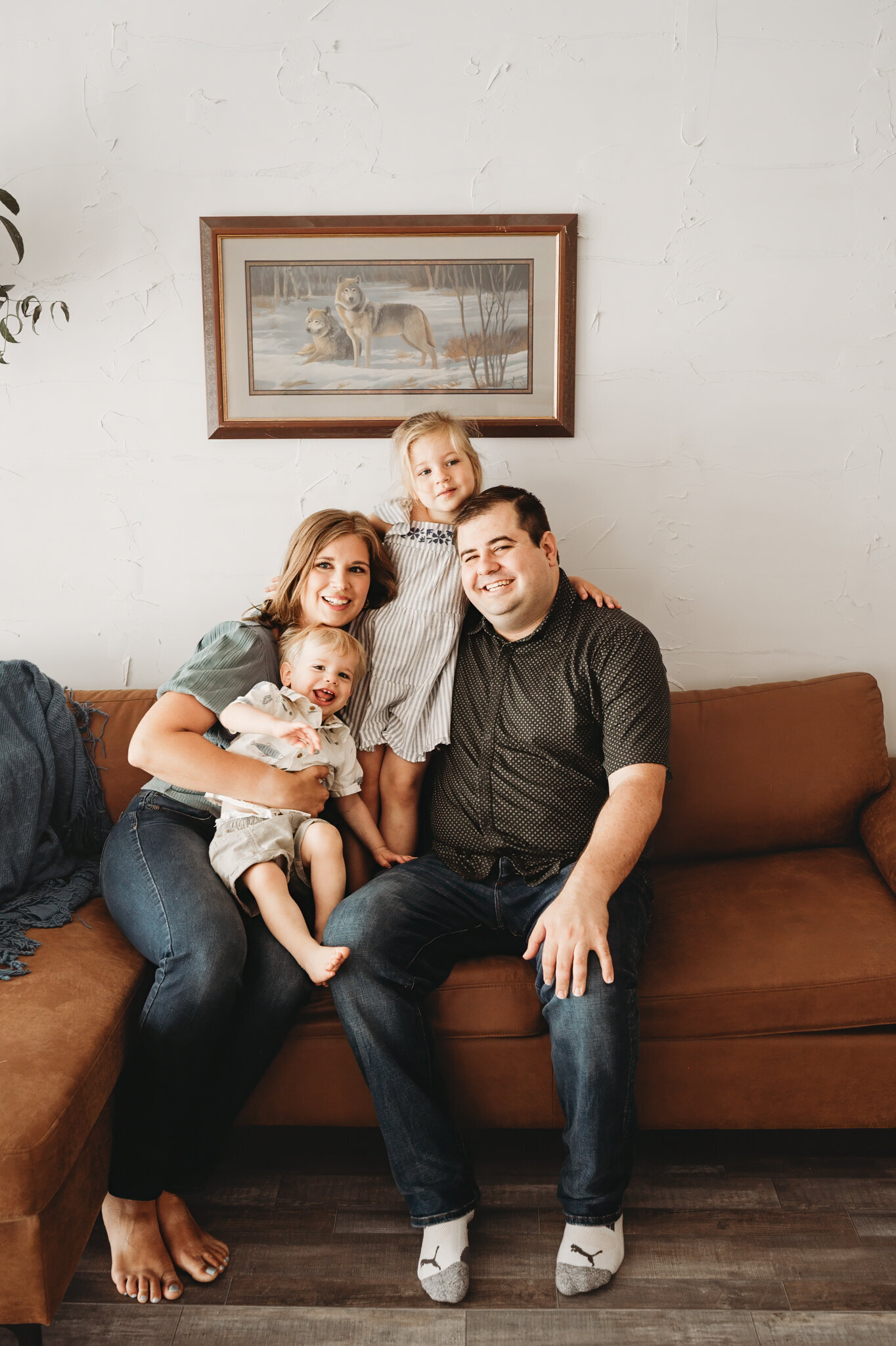 In the Nikii Pix Studios on State Street, a family embraces tightly during their milestone session. Laughter and giggles are large with this simple yet classic family session.
