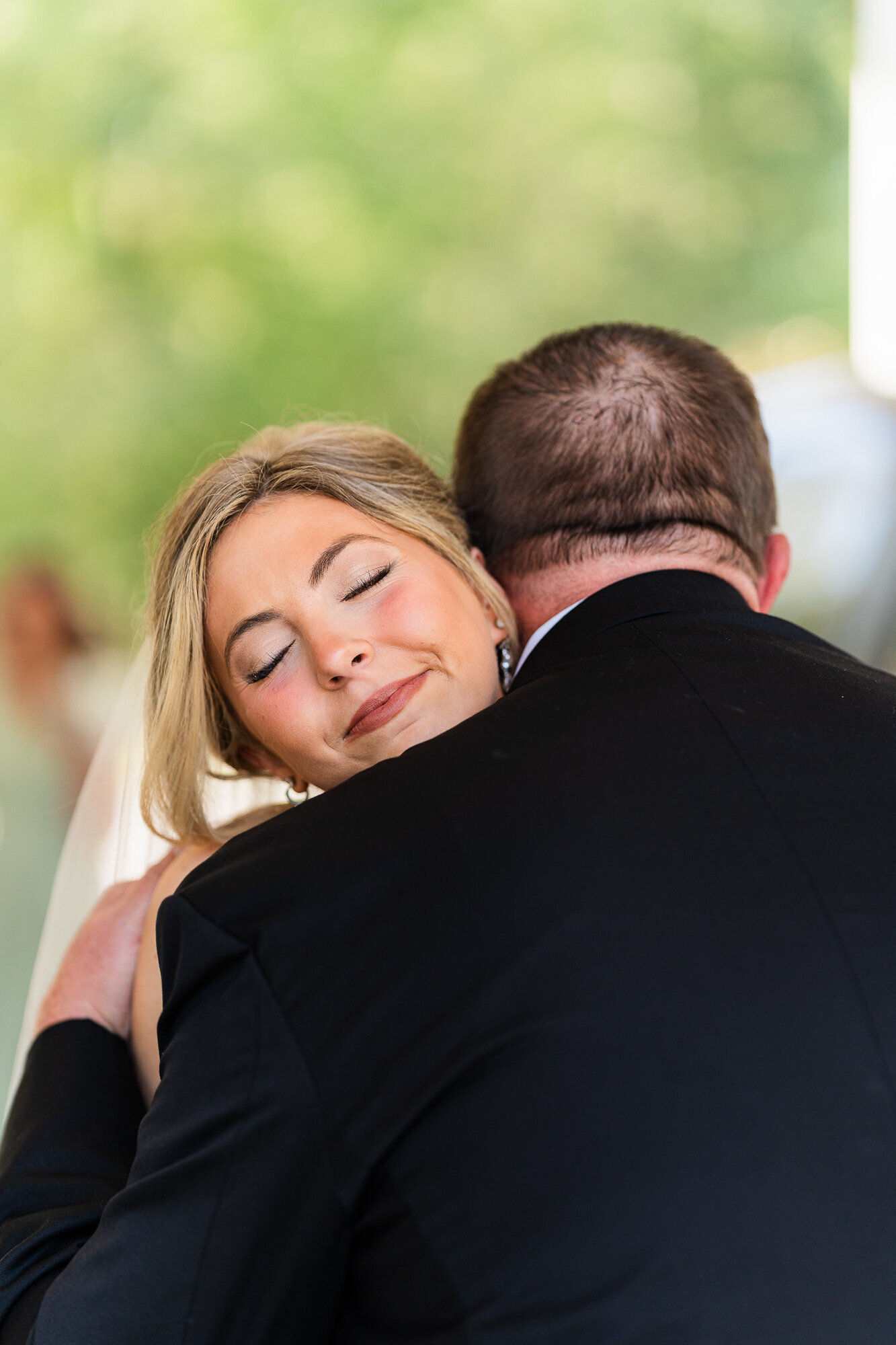 Hannah hugging her stepfather on her wedding day at the wedding venue at Daisy Hill
