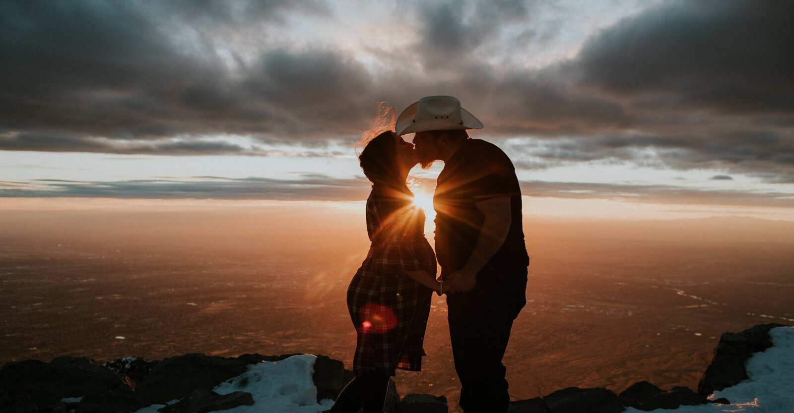 Pregnant couple kiss on Sandia Mountain Crest