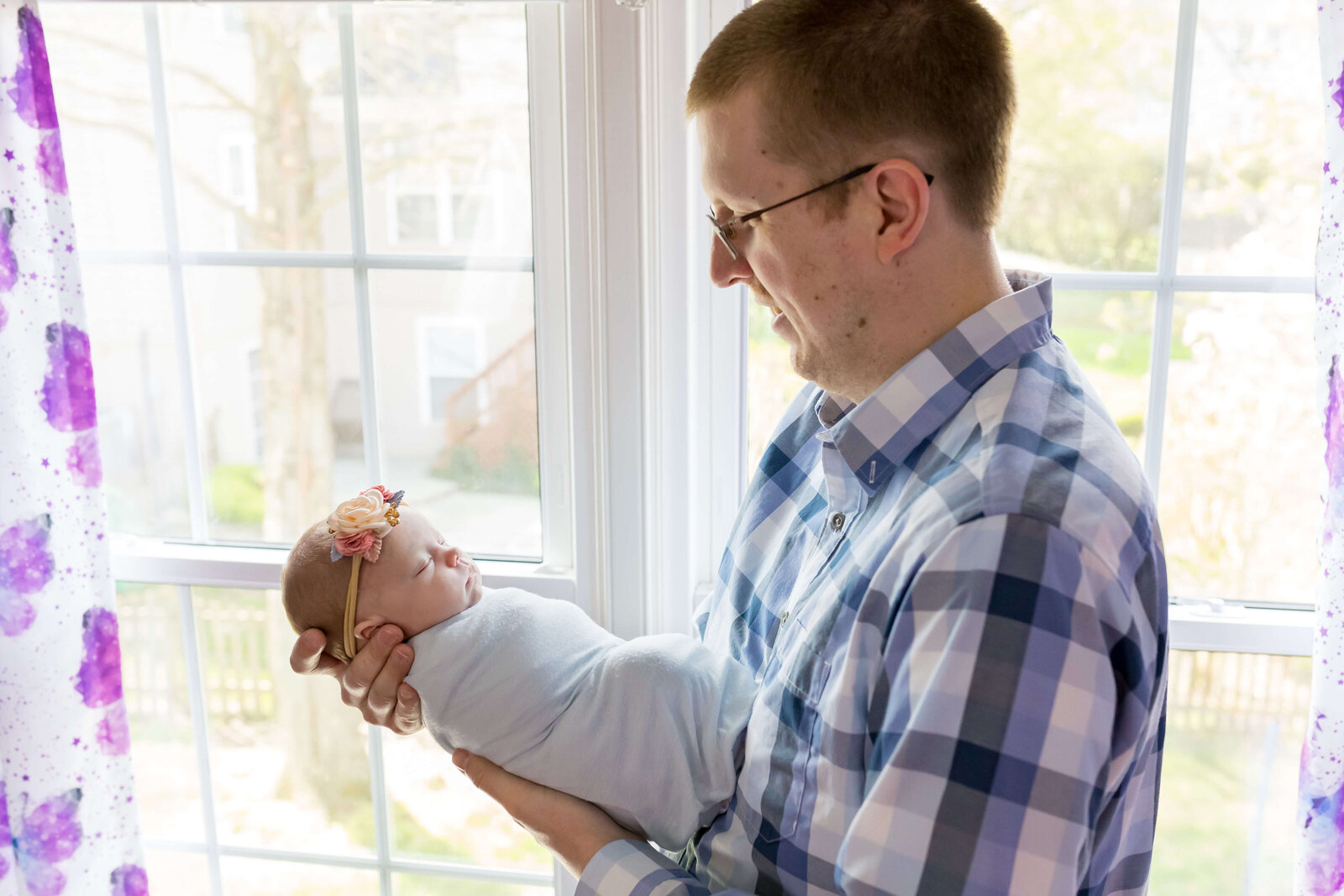 A dad looking lovingly at his baby girl in their home in Manassas.