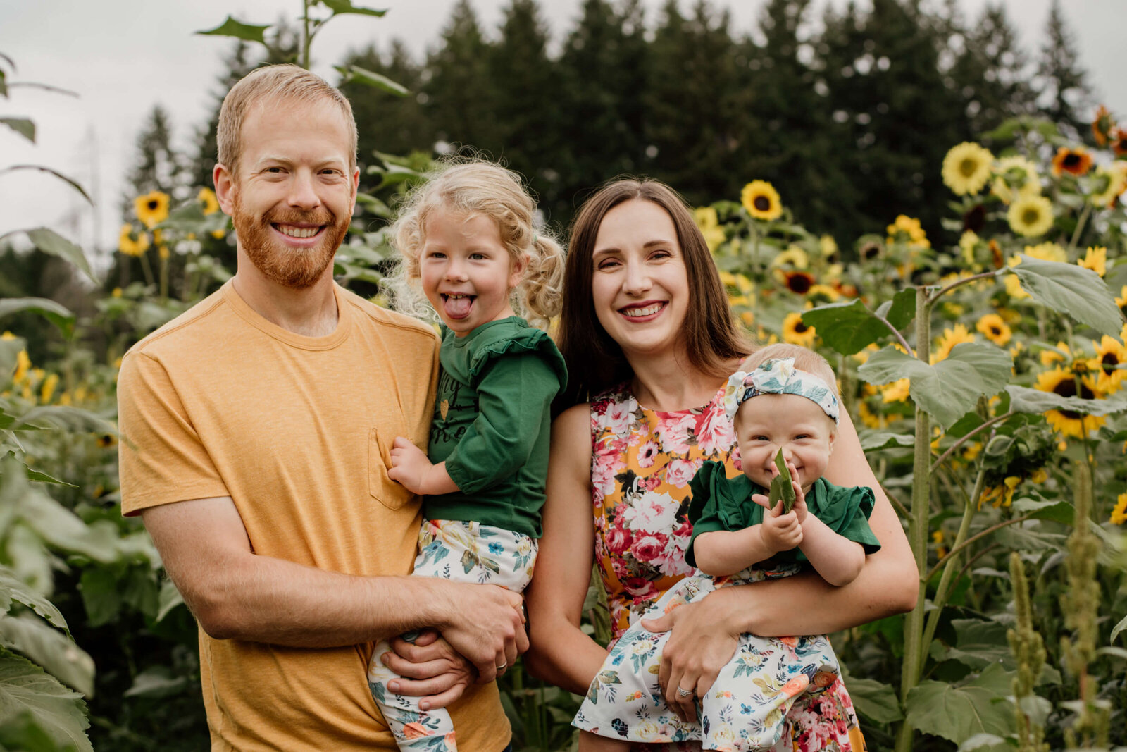 Family standing in sunflower field.