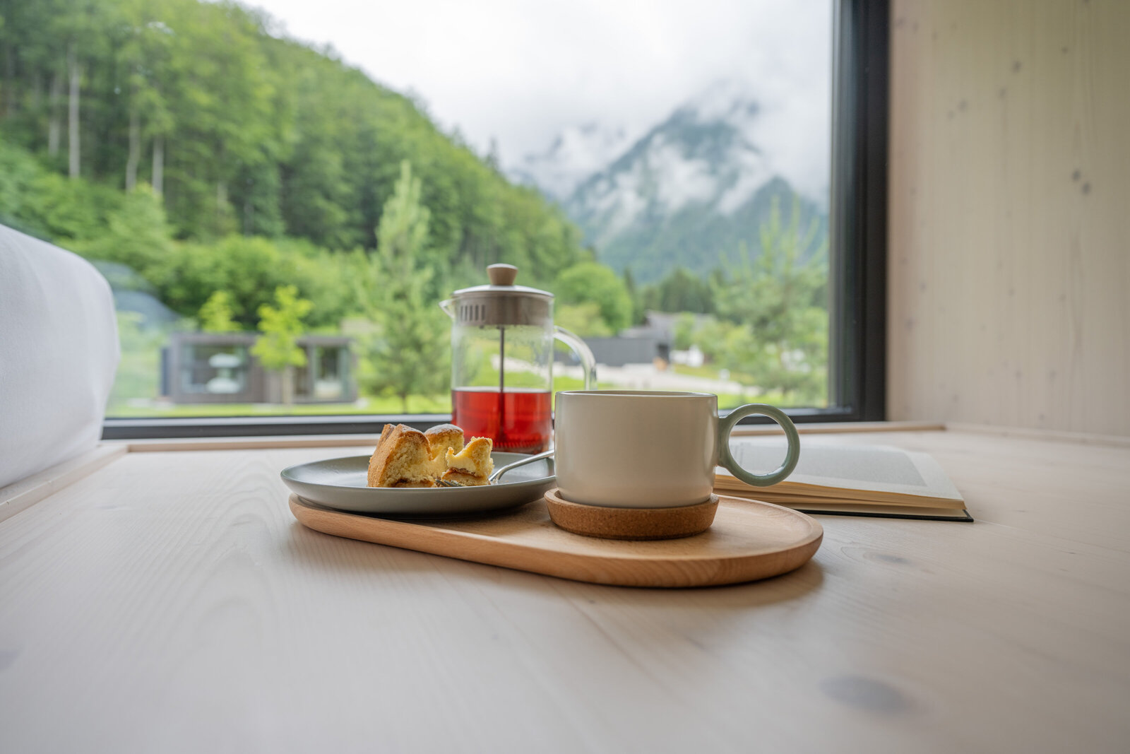 Tea and cake served inside a cozy Tiny Home at The Campus Alps.com, offering a perfect treat for relaxation during private getaways or company retreats in the scenic Alps.