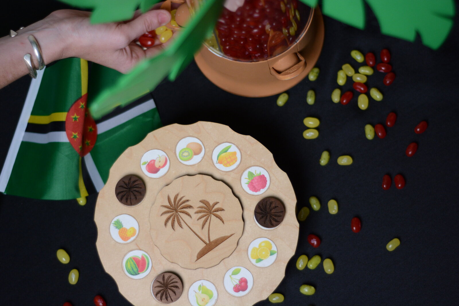 Puzzle with Dominica flag, jelly beans, and a hand taking beans from a palm tree bean dispenser