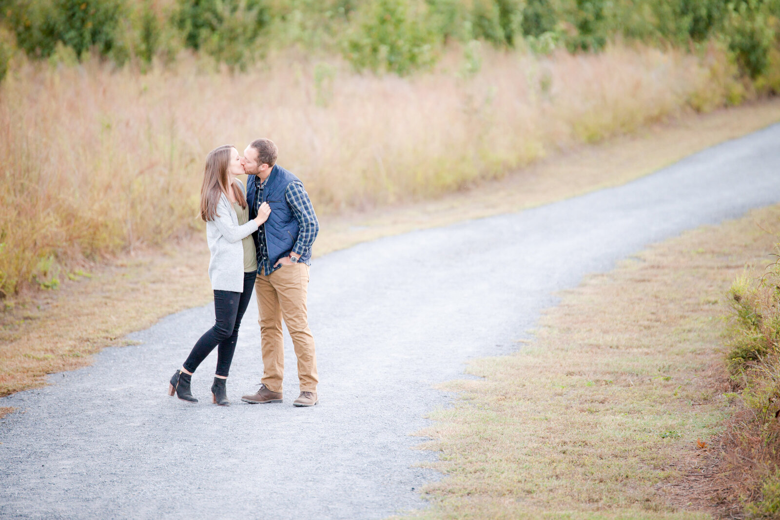 Couple kissing at a gravel pathway at a park