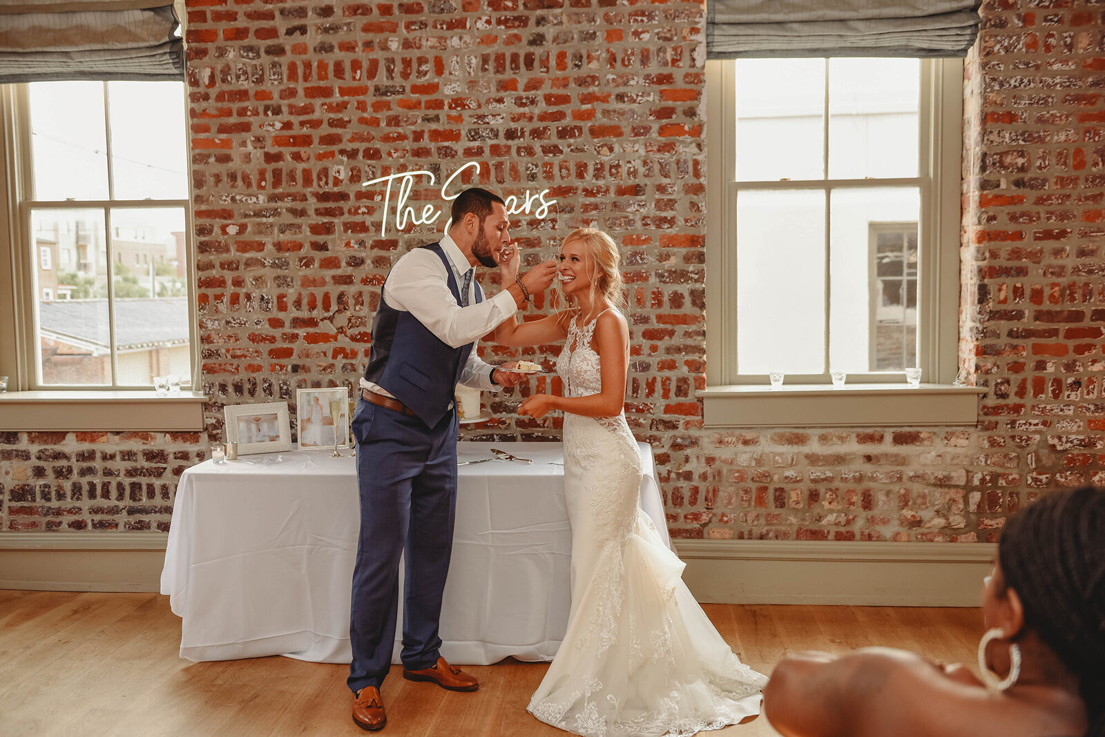 Newlyweds feed each other cake during Micro-Wedding Reception in Charleston, SC.