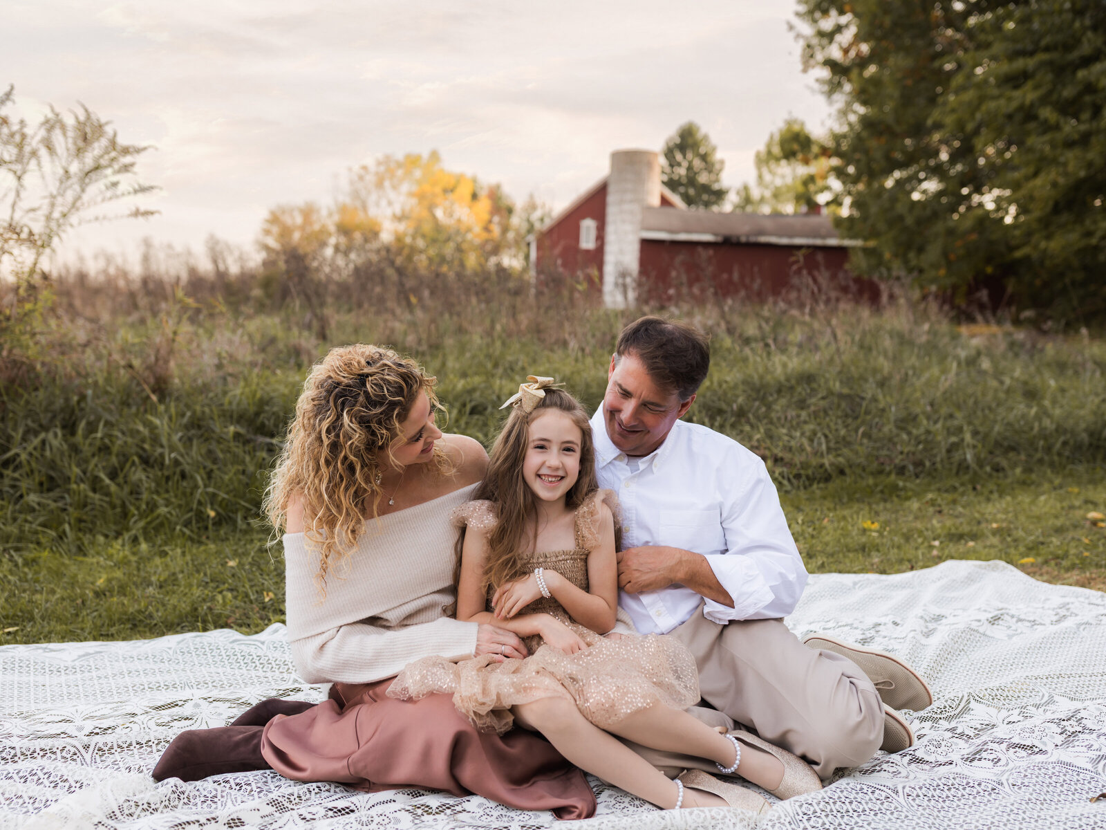 parents and daughter sitting on lace blanket for family photos at Allaradale Park in Medina, Oh Cleveland family photography