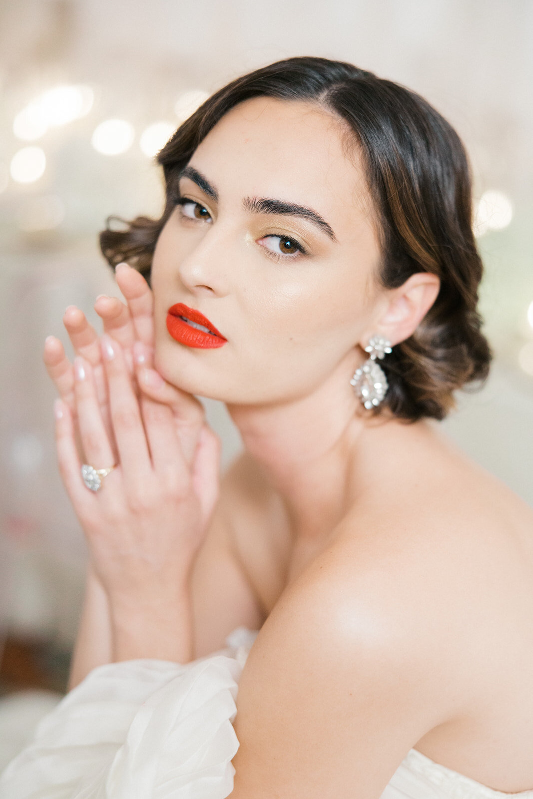 Classic regal brunette bride gazes intently with hands up and neoclassical engagement ring