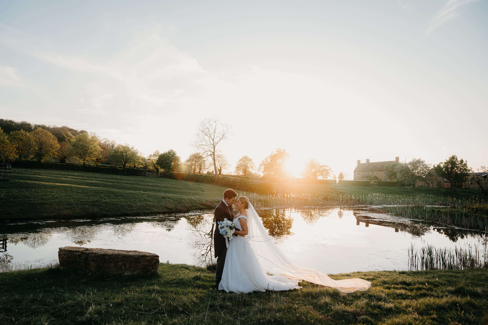 Sunset over the lake at primrose hill farm featuring a portrait of the married couple in suzanne neville dress