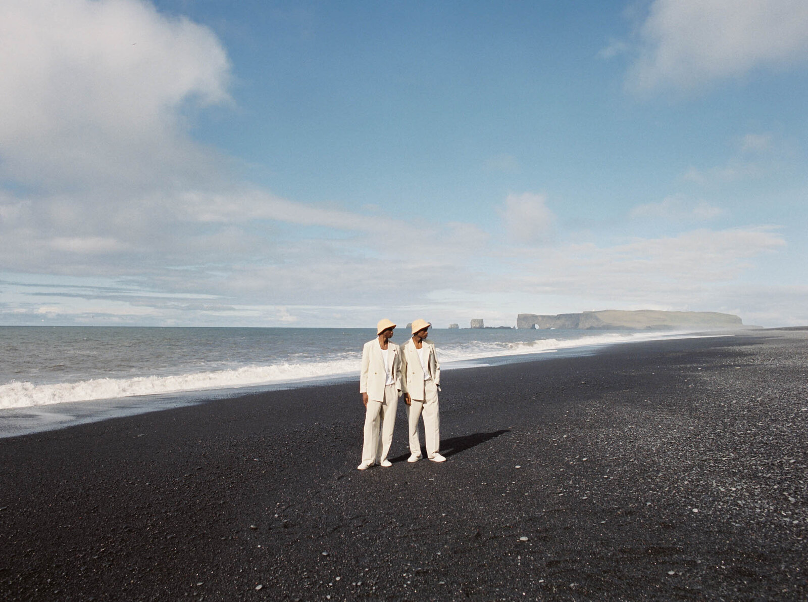Two young men on  black sand beach in Vik in Iceland