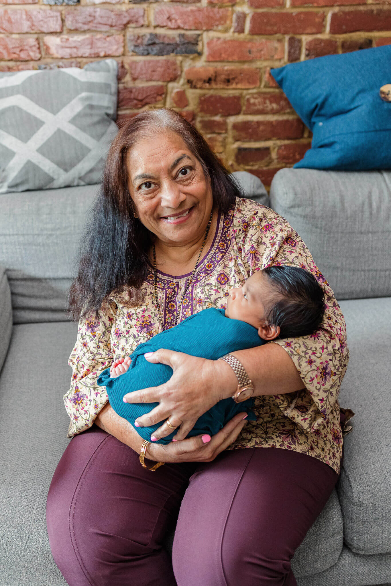 A grandma holding her newborn grandson.