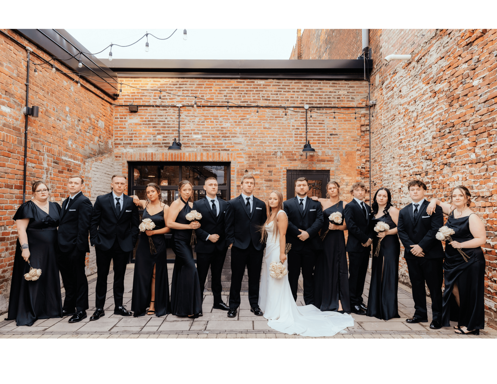 Modern wedding party in black attire at brick venue, bold and candid Michigan wedding photography for couples who love timeless style and connection