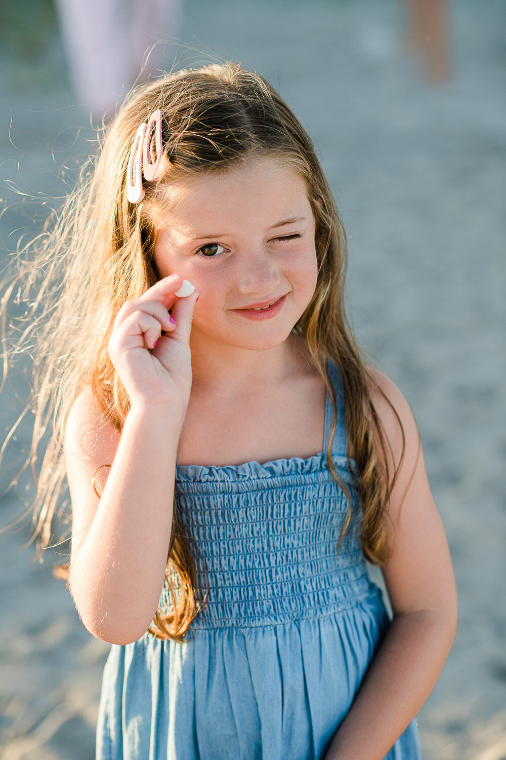 young girl on beach with shell