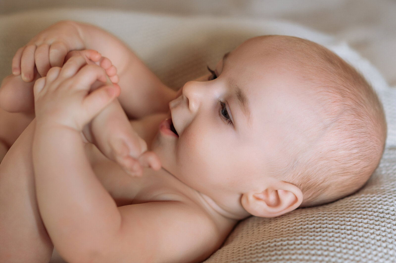baby boy laying on his back holding his feet by york pa photographer