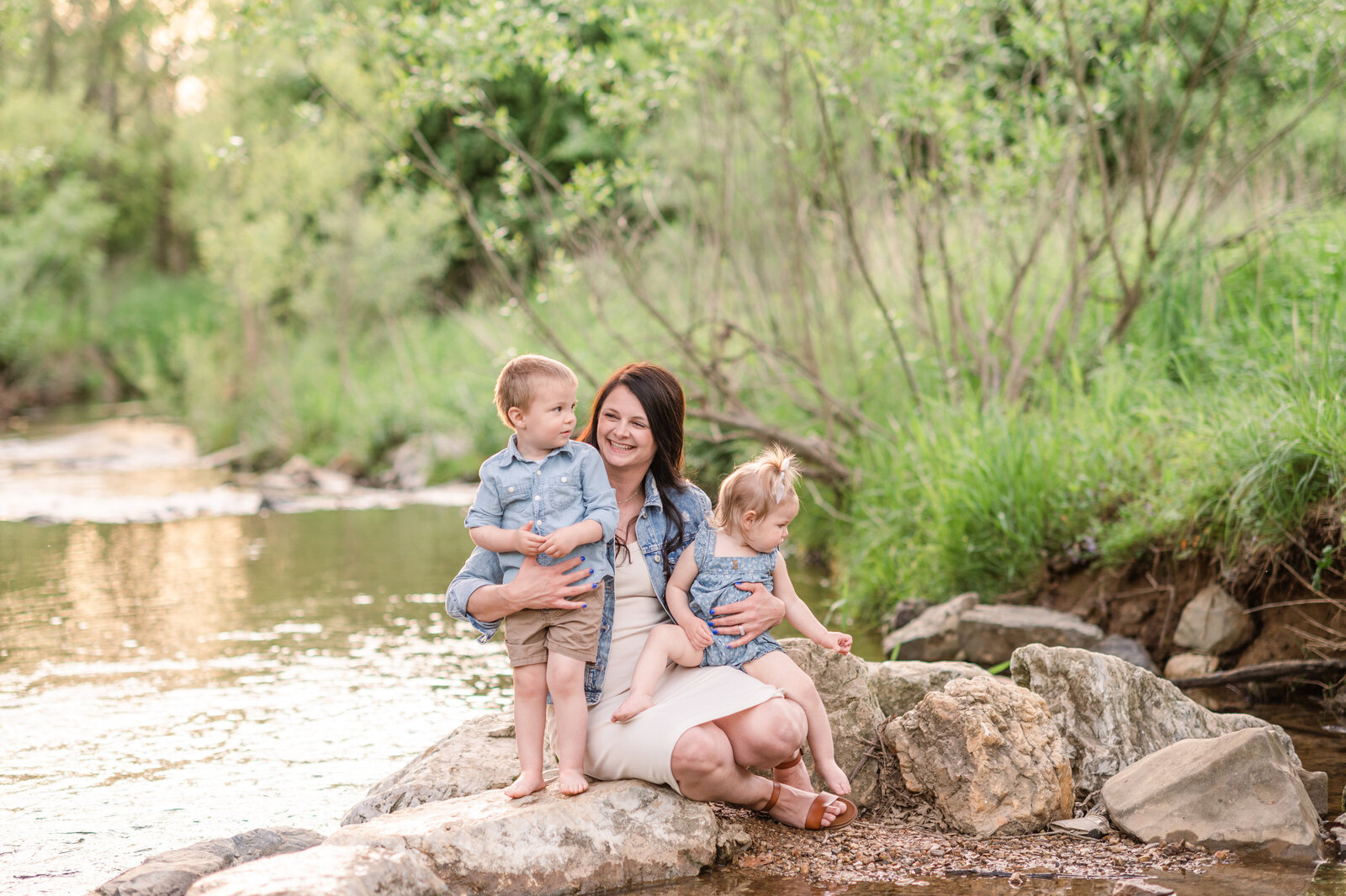 mother with son and daughter sitting on rock at creek by york pa photographer