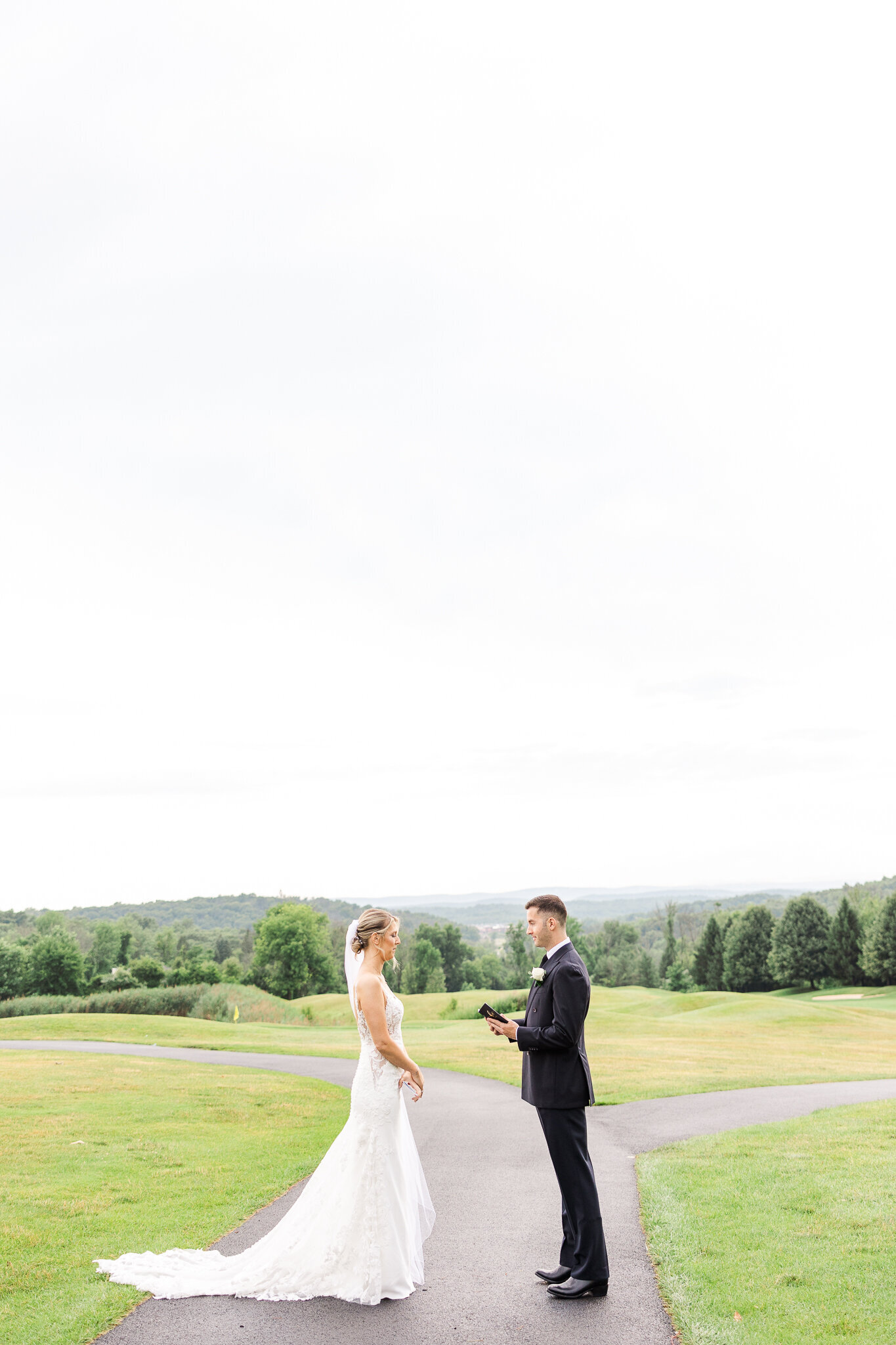 Bride and groom reading private vows to one another during their first look at SkyView Golf Club