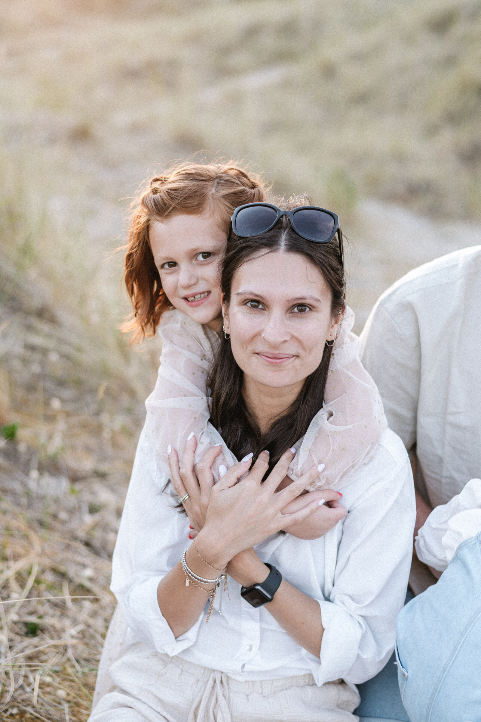 Daughter hugging mum and smiling at a family photoshoot in Billingshurst