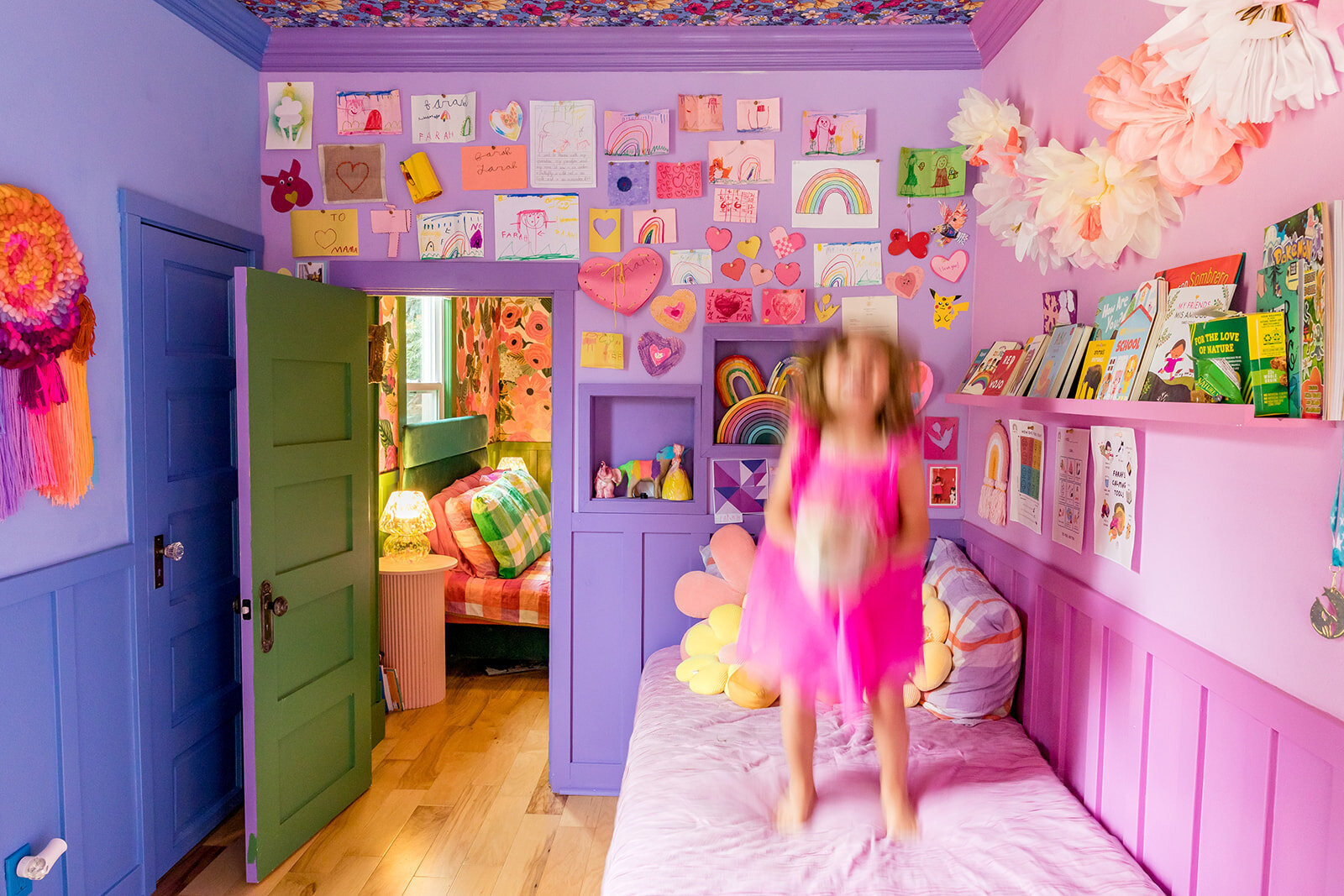 photo of a colorful kids room with girl jumping on bed