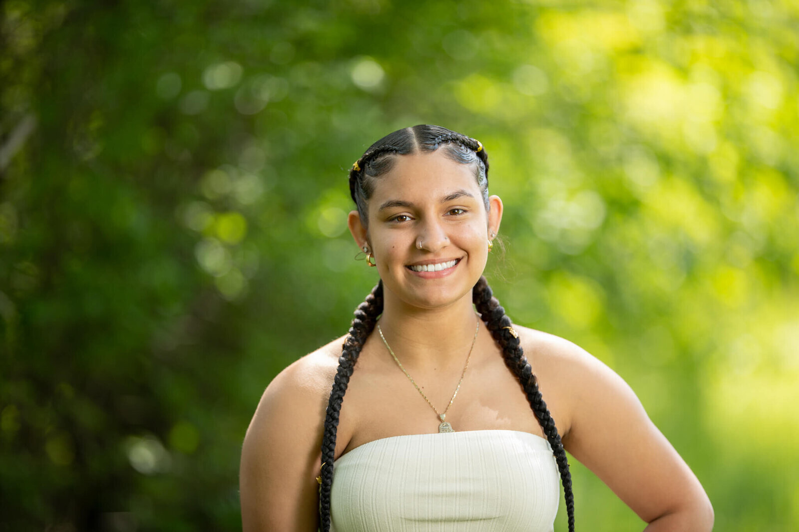 High school senior portrait photography in Clinton MA  of female in a white top smiling at the camera with a green and yellow background