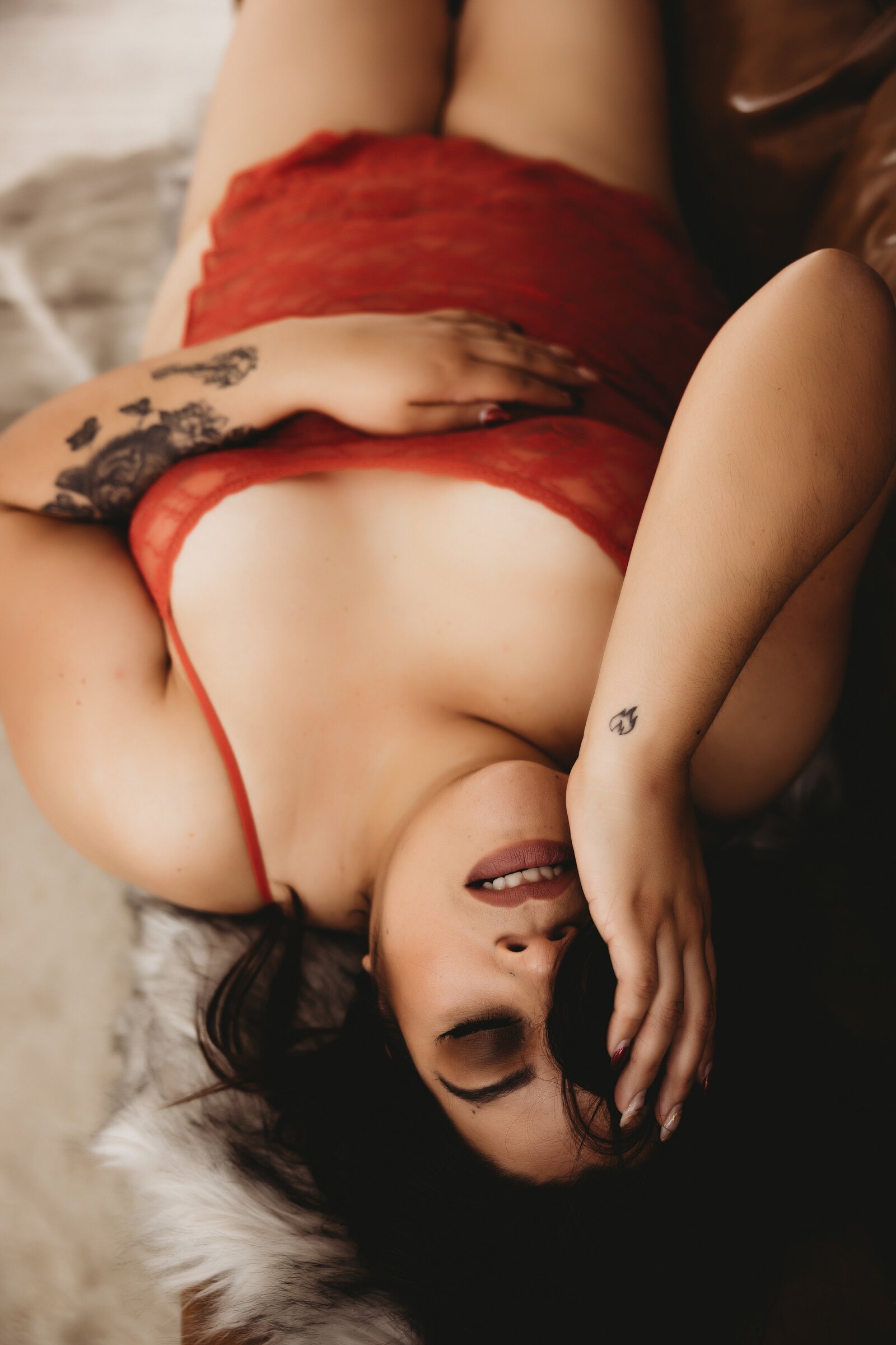 Women covers one eye with hand and hair as she lays on a couch