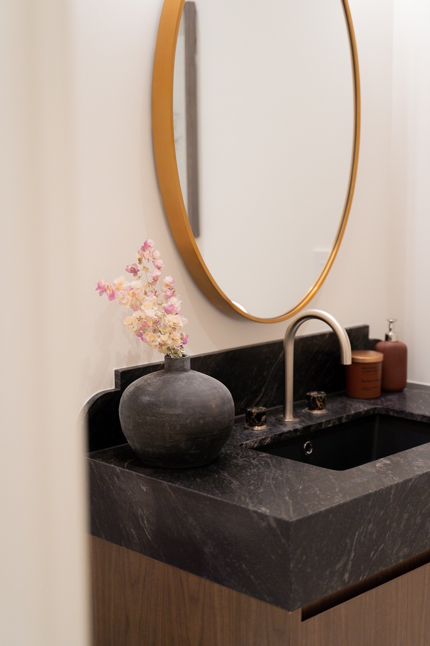 Black marble bathroom vanity with flower vase